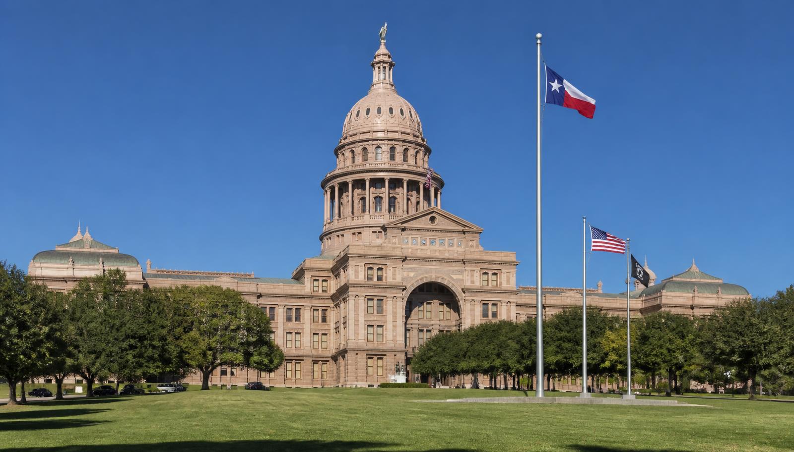 The Texas State Capitol in Austin with flags flying on poles out front